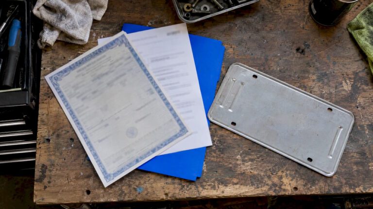 Car sale documents beside a removed plate