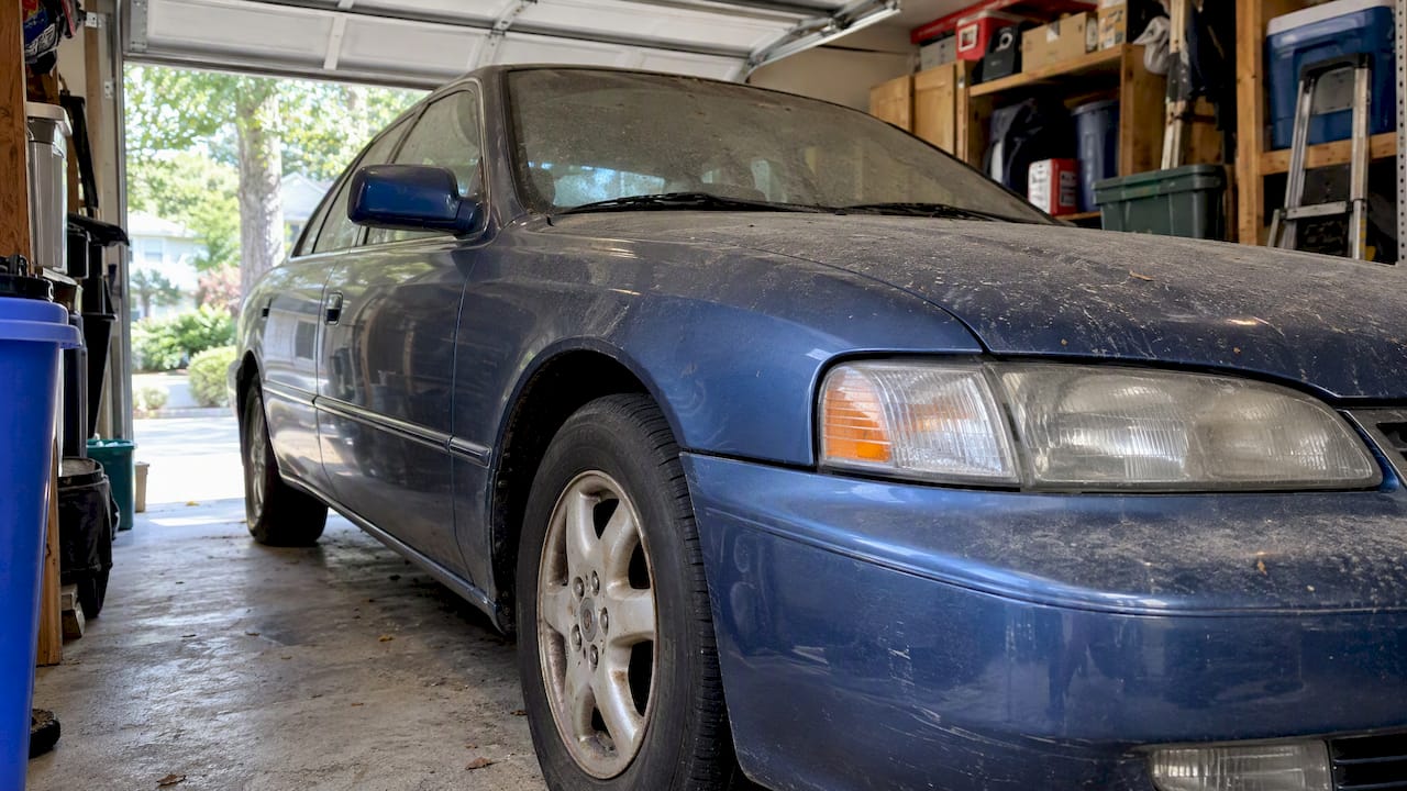 Older stationary car inside a residential garage
