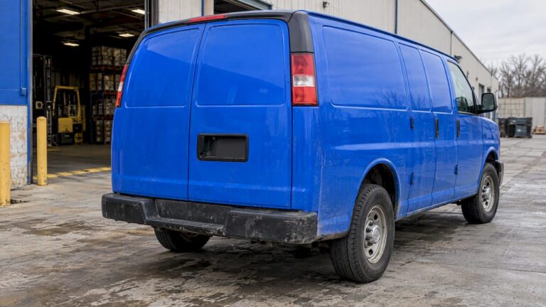 Electric-blue work van at a warehouse loading bay